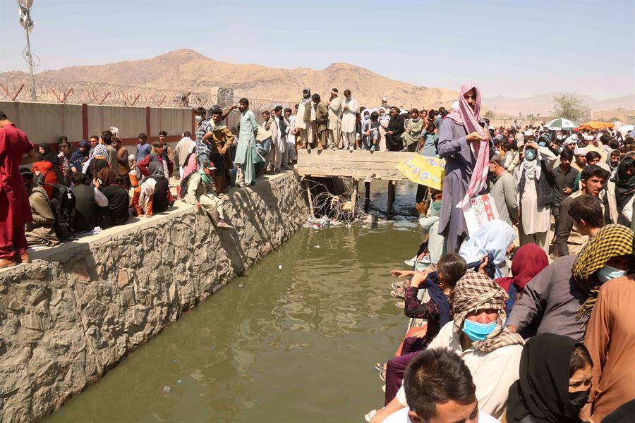 Civiles afganos esperan en el exterior del aeropuerto Hamid Karzai de Kabul para mostrar sus acreditaciones y abandonar el país el 26 de agosto de 2021.  Al menos 13 personas fallecieron ese mismo día, entre ellos algunos menores, en una explosión en el exterior del aeropuerto