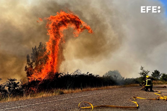 A CAÑIZA (PONTEVEDRA), 31/07/2022.- Efectivos de bomberos trabajan este domingo en la extinción de un incendio forestal en la carretera N120, actualmente cortada por las llamas, en A Cañiza (Pontevedra). EFE/ Sxenick RESUMEN FOTOS DEL AÑO DE EPA 2022 AGOSTO