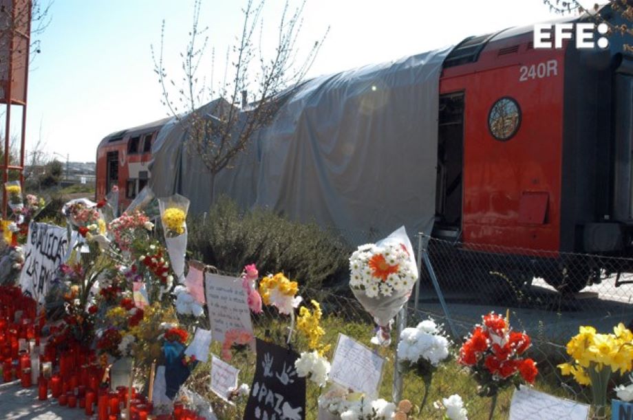 MADRID, 14-3-04.- Numerosas flores y velas aparecen en la estación de El Pozo, frente a uno de los vagones donde se produjeron las explosines en los atentados del pasado día 11 en Madrid. EFE/DOLORES LARA