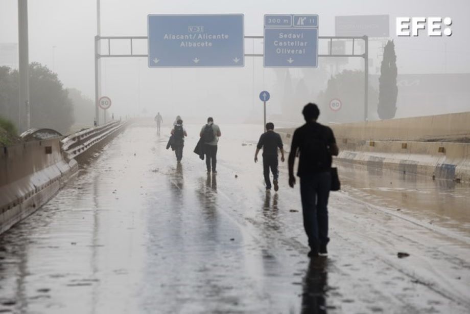 Sedaví (Valencia), 30/10/2024.- Varias personas transitan por la V-31 cerrada al tráfico a causa de las lluvias torrenciales provocadas por la dana EFE/Miguel Ángel