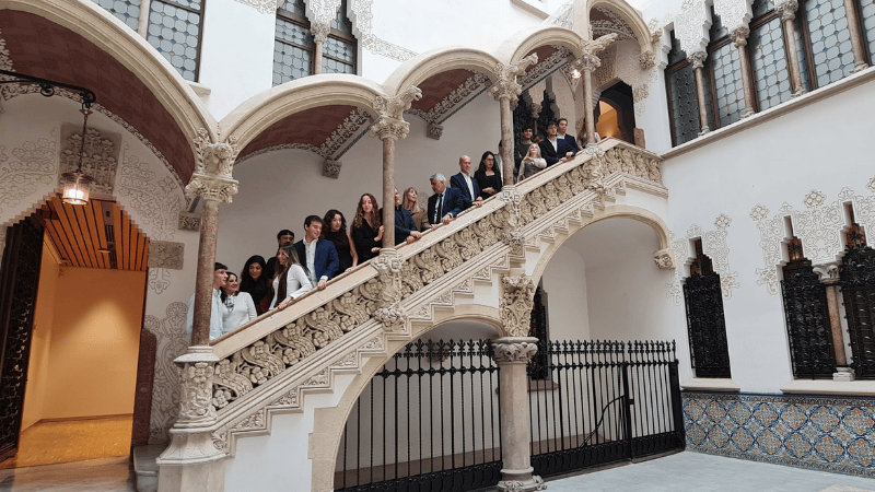 Foto grupal en la escalera de los alumnos de las Becas Caixa Promoción 20 y en el centro está Miguel Ángel Oliver, Presidente de la Agencia EFE