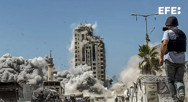 Un periodista filma un ataque aéreo israelí contra la Torre Mushtaha, al oeste de la ciudad de Gaza. EFE/EPA/Mohammed S